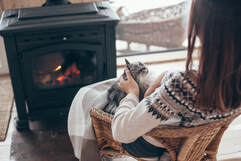 A Ramoneur Sherbrooke customer enjoys the fireplace with her cat. The chimney was swept by Ramoneur Sherbrooke.